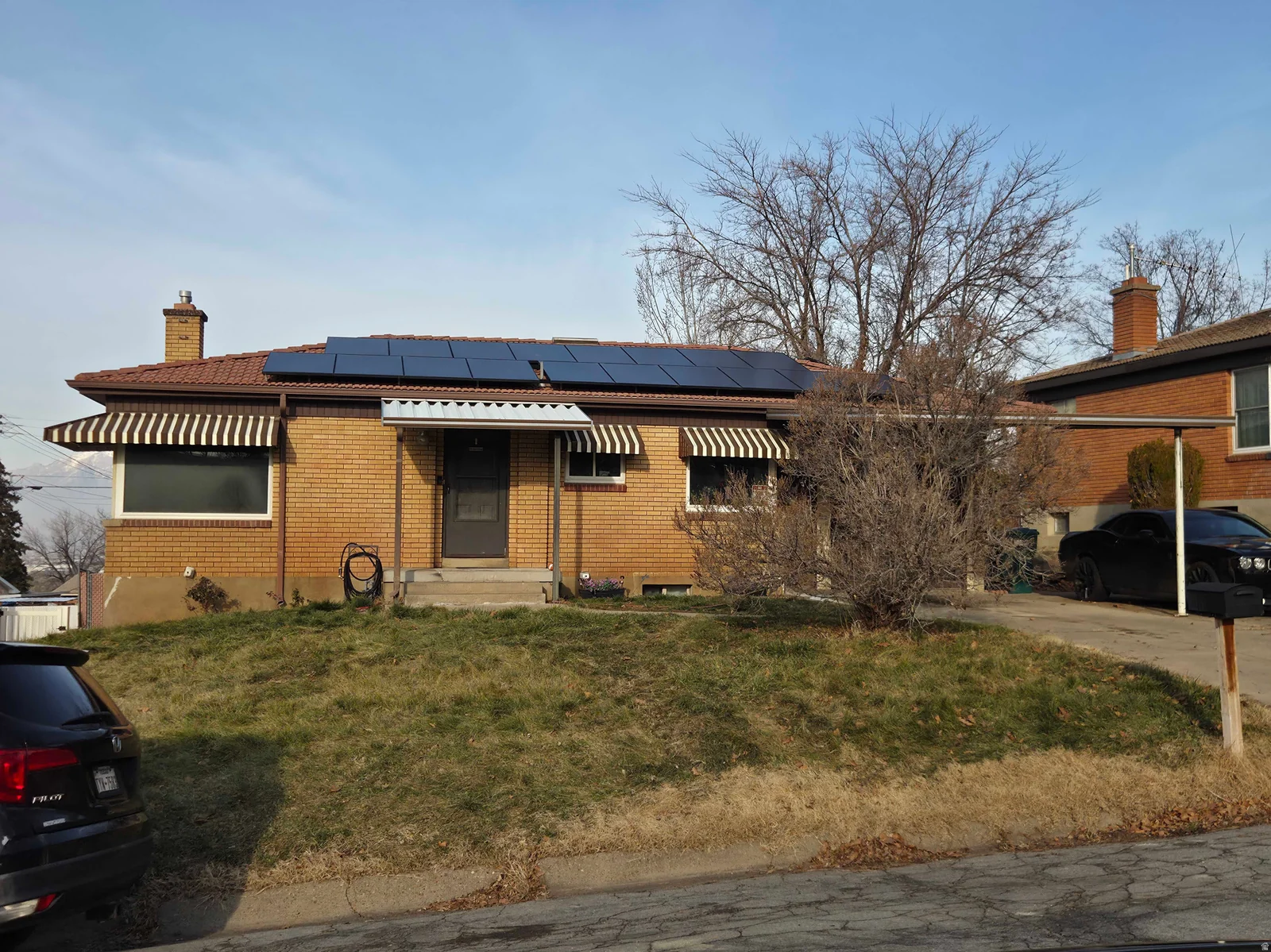 Single story home with a front lawn, brick siding, and a chimney